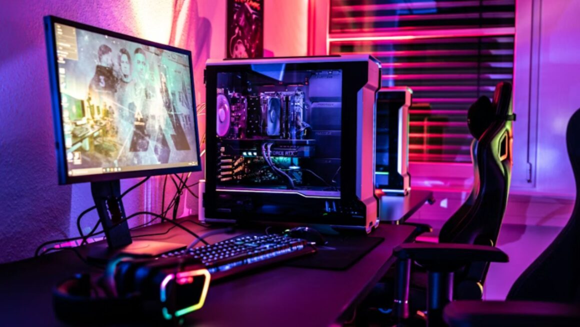 A gaming setup with a monitor, gaming PC, keyboard, headphones, and colourful lighting